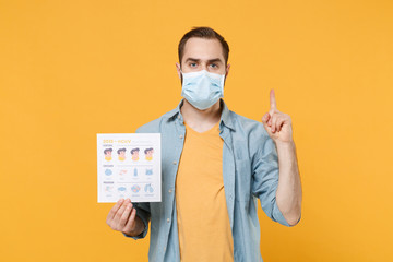 Young man in face mask isolated on yellow background. Epidemic pandemic coronavirus 2019-ncov sars...