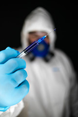 Close up portrait image of a health worker wearing protective clothing and masks working with Vaccines for dangerous viruses