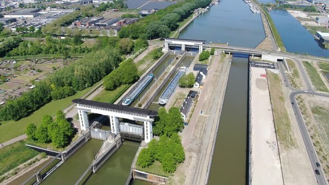 4k aerial video of Princess Beatrix sluice complex in the Netherlands with two inland vessels in the lock. Waterways transportation infrastructure.  