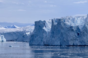 Fototapeta na wymiar Glacier front in antarctic sea, Antarctica, blue sky, Stonington Island
