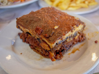 delicious Greek mousaka close up, gourmet plate with minced meat, eggplants, potatoes and bechamel