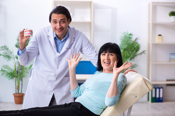 Old woman visiting young doctor dentist