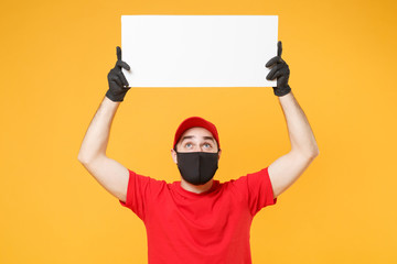 Delivery man in red cap t-shirt uniform sterile face mask gloves hold blank sign board isolated on yellow background studio Guy employee Service quarantine pandemic coronavirus virus 2019-ncov concept