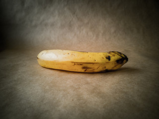 Yellow overripe banana on a dark background
