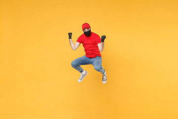 Obraz na płótnie Canvas Fun jumping delivery man in red cap t-shirt uniform sterile face mask gloves isolated on yellow background studio Guy employee courier Service quarantine pandemic coronavirus virus 2019-ncov concept.
