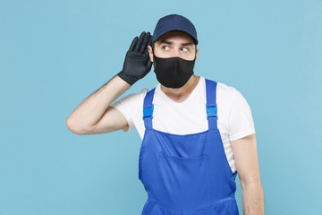 Delivery man in cap t-shirt coveralls uniform sterile face mask gloves isolated on blue background...