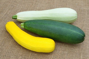 Three zucchini of different colors on burlap