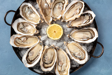 A dozen of oysters with a lemons, close-up overhead shot