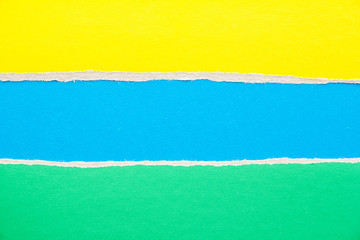 Blue, green and yellow torn cardboard paper background with copy space for text message.