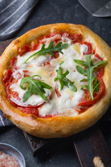 Pizza Margherita on black stone background, top view.