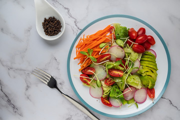 healthy vegan bowl. Avocado, tomato, Red Radish,carrot, Sunflower seedling,Black pepper, lemon,  and vegetables salad. Top view. vegan food, clean eating, dieting