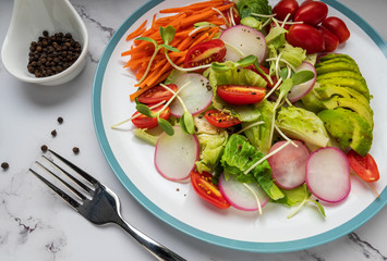 healthy vegan bowl. Avocado, tomato, Red Radish,carrot, Sunflower seedling,Black pepper, lemon,  and vegetables salad. Top view. vegan food, clean eating, dieting