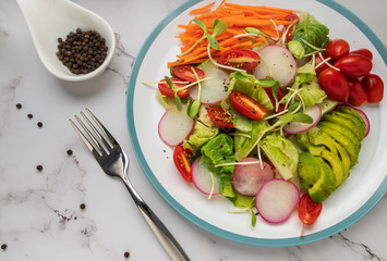 healthy vegan bowl. Avocado, tomato, Red Radish,carrot, Sunflower seedling,Black pepper, lemon,  and vegetables salad. Top view. vegan food, clean eating, dieting