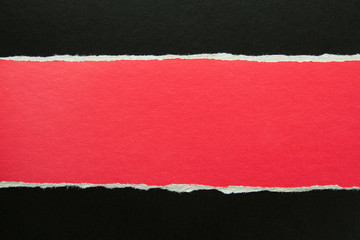 Torn red stripe of cardboard on black paper texture background. Can be used for text message.
