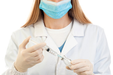 Close up of a syringe held in the hands of a scientific researcher wearing a surgical mask