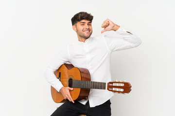 Young handsome man with guitar over isolated white background proud and self-satisfied