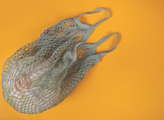 Cabbage in a string shopping bag on the yellow background. Eco shopping products.