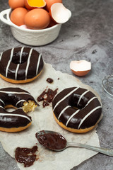 chocolate donuts and eggs on a gray background
