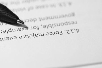 Definition of force majeure in a contract on a sheet of white office paper.