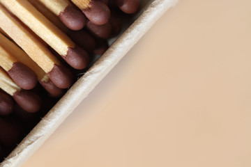 Macro photo of an open matchbox with wooden matches on a table background made of plywood.