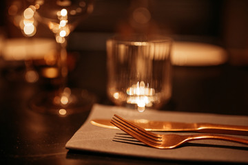blurred tеable setting in a restaurant. Fork close up, warm brown tinted