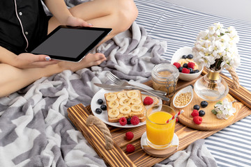 Young woman working from home works in the morning on the tablet