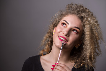 Obraz premium Beautiful young girl with colourful makeup. Make up, crazy hairstyle, lipstick, eye shadows, hair. 