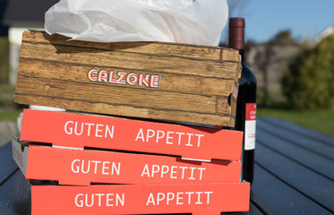 stack of cardboard box for pizza with german inscription for enjoy your meal