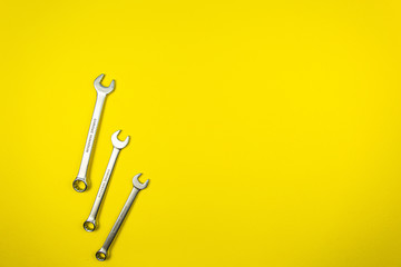 Set of wrenches of different sizes on a yellow background
