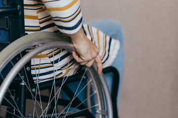 Unrecognizable disabled woman in wheelchair at home. Recovery and healthcare concepts.