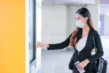 Beautiful business woman with hygiene mask point to sky train or transportation map at the station to select the destination of working during Covid-19 pandemic in city.
