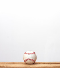 pelota de béisbol en un fondo blanco sobre una mesa de madera 
