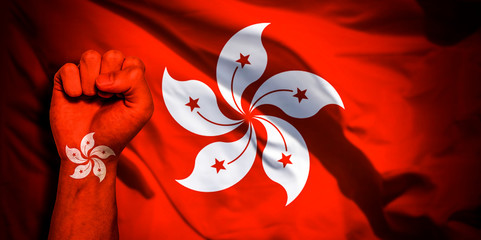 Banner of Flag of Hong Kong painted on male fist, fist flag, country of Hong Kong, strength, power, concept of conflict. On a blurred background