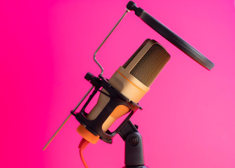 old-style microphone for podcasting on a fuchsia background