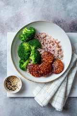 Marinated tempeh in smoky bbq sauce marinade or teryaki tempeh with rice and steamed broccoli