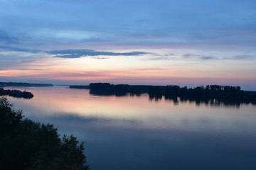 The wide river Danube landscape. Reflection of purple-blue sky in water