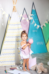 Little girl plays wigwam with colorful toy bricks and builds tower. Happy baby plays in tent in children's room with educational toys. baby plays in kindergarten. childhood concept, child development  © stock_studio