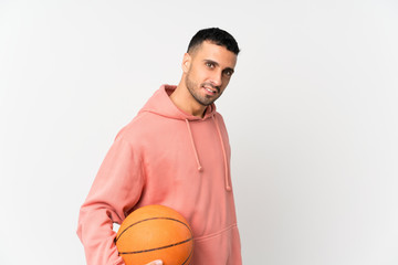 Young man over isolated white background with ball of basketball