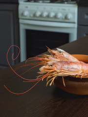 Fresh prawns on the kitchen table in a bowl. Cooked fresh giant prawns