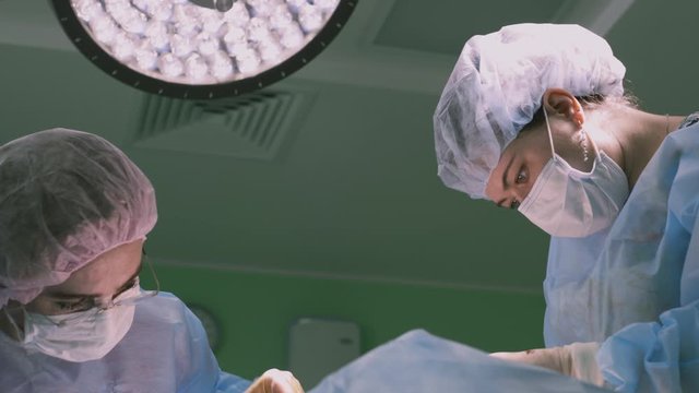 Theater operating room, professional surgeons during the operation, on the face. Plastic surgery to reconstruct the face of the patient. Modern medicine. 4k