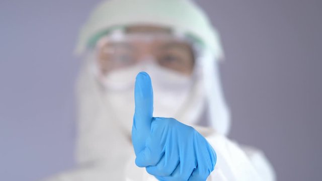 Healthcare Worker in Full PPE Suit Giving Thumbs Up Gesture