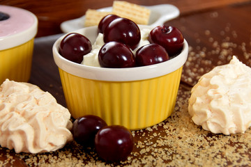 yogurt with cherry fruit, cookies and wafers on scattered sugar
