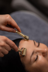 professional masseur use derma roller for lifting face care, clients came in luxury spa salon to...