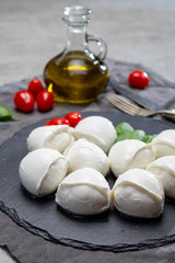 Tasty italian food, fresh white buffalo mozzarella soft cheese balls from Campania, tomatoes, fresh basil and olive oil
