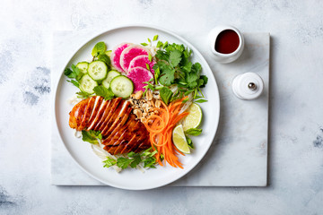 Vietnamese rice noodle salad with marinated grilled chicken, raw vegetables, roasted peanuts, toasted sesame seeds and fresh herbs