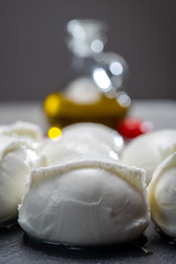 Tasty italian food, fresh white buffalo mozzarella soft cheese balls from Campania, tomatoes, fresh basil and olive oil