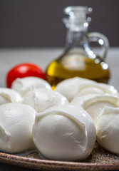 Tasty italian food, fresh white buffalo mozzarella soft cheese balls from Campania, tomatoes, fresh basil and olive oil