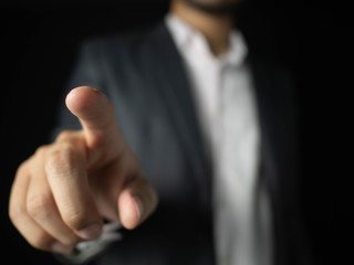 Fototapeta premium Businessmen wear suits pointing to touch something Is an object for graphic lines, able to add anything. With a black background, business, or financial concept.