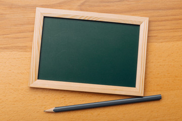Clean vintage chalk board on a wooden table.