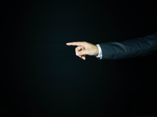 The hands of the businessman are pointing to touch something Is an object for graphic lines, able to add anything. With a black background, business, or financial concept.